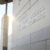 Exterior of side of stone building with the words "Harvard T.H. Chan School of Public Health" adhered in silver. A sunflare peaks through a stone column on the left.