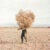A man holds a dead tree limb and foliage in a dry Moroccan dessert that he collects to fuel his kiln.