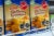 Boxes of cookies, labeled in Spanish, line a supermarket shelf. Three black warning labels on each box warn that the product is "high in calories"; "high in sugars"; and "high in saturated fats."