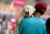 A man with his back to the camera carries a child, head covered with a towel to protect from the heat, in Jammu, India.