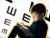 Photo illo: A young boy sits and plays with a glowing tablet. Behind him is an oversized eye chart that blurs on the sides.