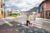 A man holds a child's hand as they cross a street at an intersection in Quito.
