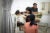 Sisary Kheng talks with a young patient and her family at Exceed worldwide. The girl sits on an elevated chair.