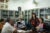 Sisary Kheng in a conference room with other coworkers at a table at Exceed Worldwide in Camboida.