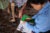 A prosthetics patient with a missing leg limb gets his chart reviewed and leg cared for a by a community health care worker near his home in Cambodia.