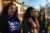 Three women wearing hoodies and t-shirts pose for the camera. They are part of a womanhood support program working with eighth graders in Waukegan, Illinois.
