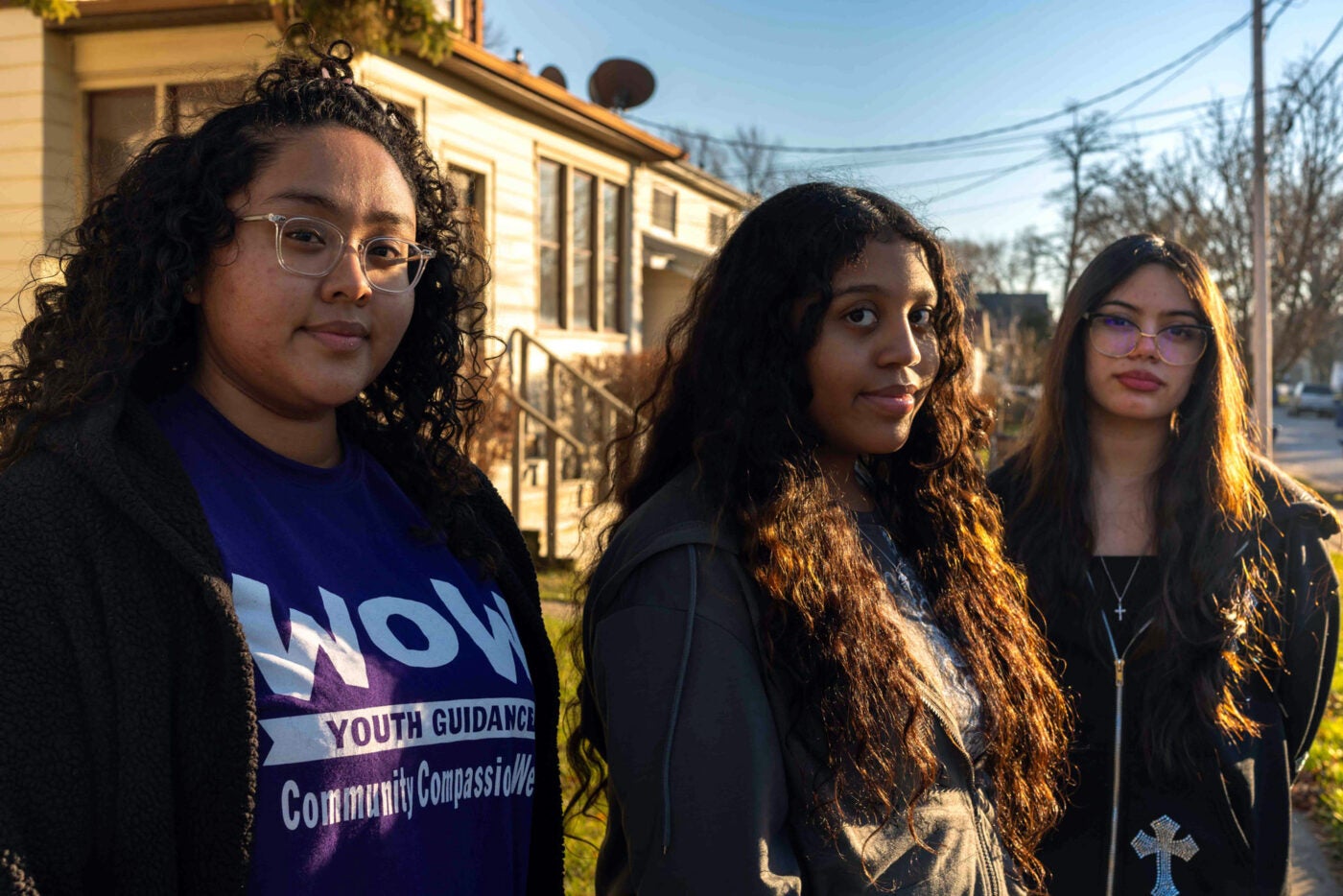 Three women wearing hoodies and t-shirts pose for the camera. They are part of a womanhood support program working with eighth graders in Waukegan, Illinois.