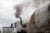 A diesel semi-truck emits dark smoke while stuck in traffic.