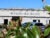 A photo of the Bethesda health clinic from the parking lot. The building is a tan, one story building with a few windows.
