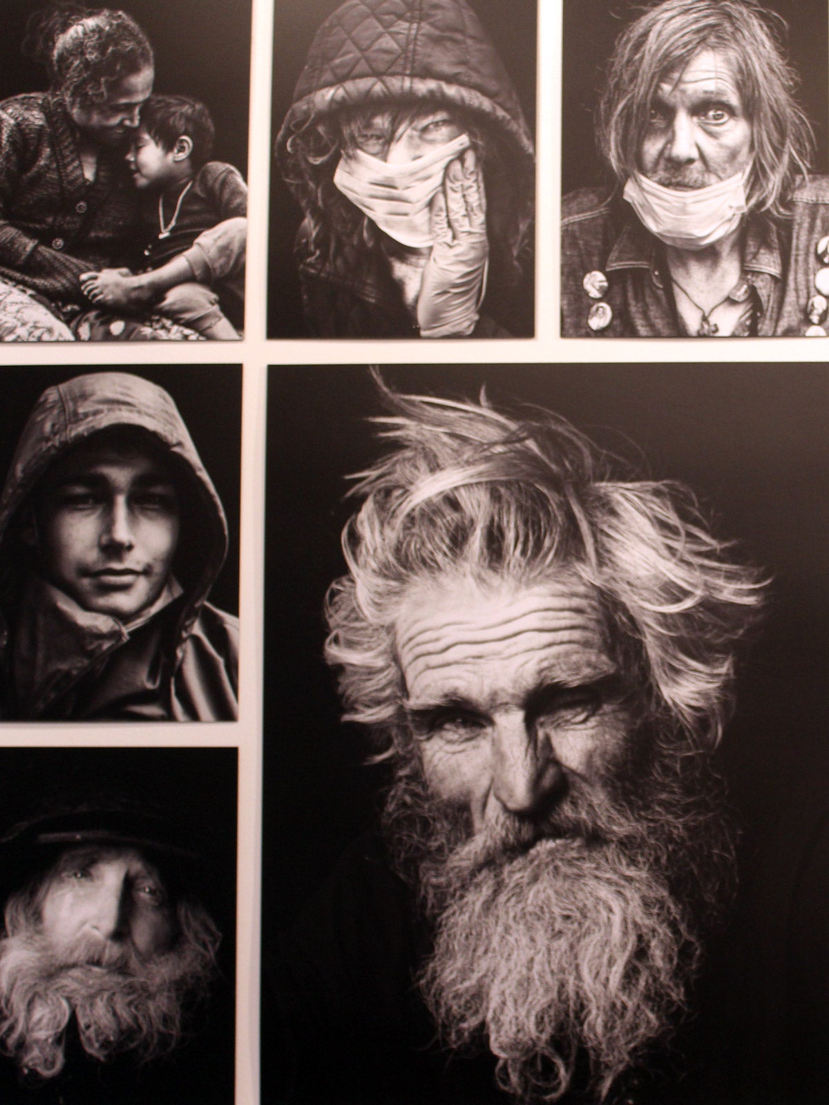 Close-up of black and white portrait photos of unhoused people in various expressions.