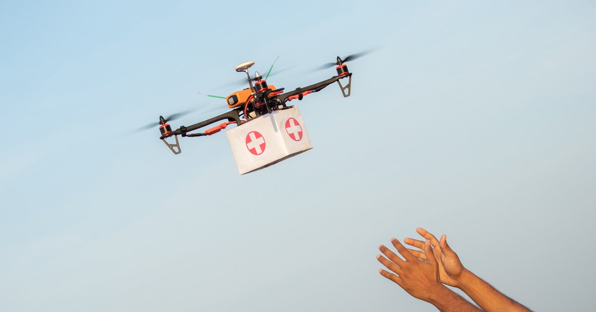Drone carries first aid box to a pair of outstretched hands.