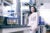 Mariana Matus, dressed in a light pink suit, standing in a lab with a vial of testubes in the foreground.