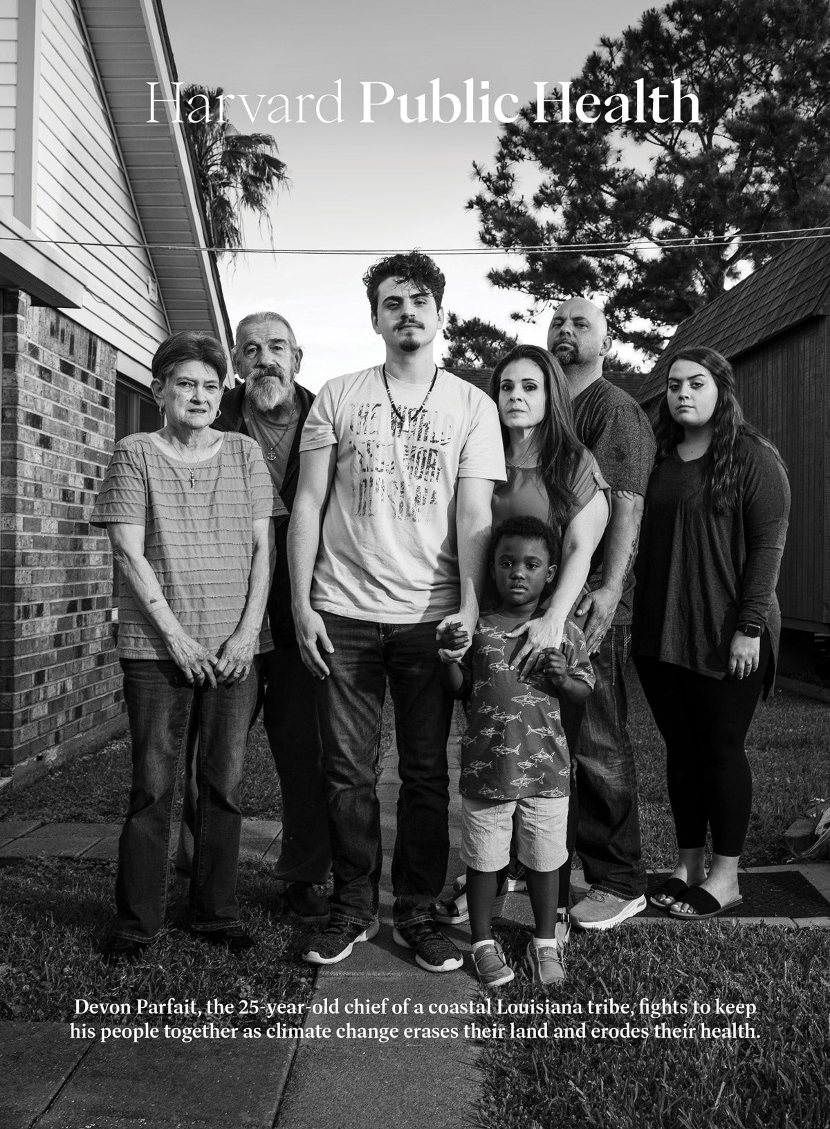 Cover of Harvard Public Health, Spring 2023. Photo: Black and white photo: Seven family members stand close together and stare directly into the camera. In the center is a twenty-something man, who holds the hand of a young black boy. To his left are an elderly man and woman. To his right are a middle-aged woman who holds the young boy's other hand, a middle-aged man, and a young woman. They stand in a backyard, with a grill and house on one side, and a modern tipi on the other. Text reads: Devon Parfait, the 25-year-old chief of a coastal Louisiana tribe, fights to keep his people together as climate change erases their land and erodes their health.