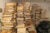 Large stacks of medical records in file folders nearly reach the ceiling in an office room. Some are in black trash bags.