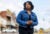Shenelle Ball-Burks stands outside, looking off camera, and wears a denim jacket and black dress.