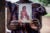 An African woman holds a worn photo of an infant in her hands.